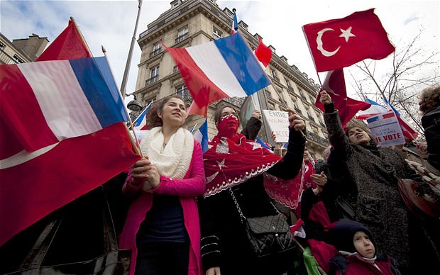 Franco-Turkish demonstrators wave French and Turkish flags near the French Senate in Paris